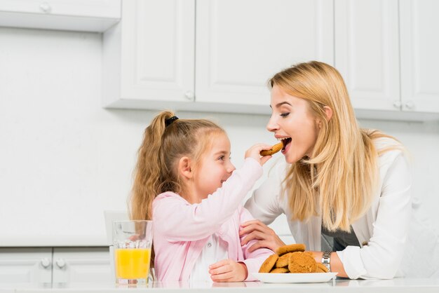 Madre e figlia con biscotti e succo