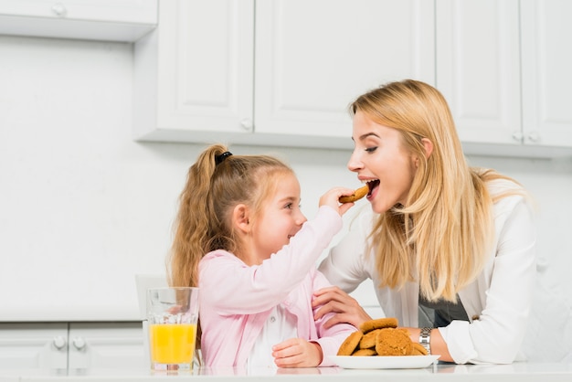 Madre e figlia con biscotti e succo