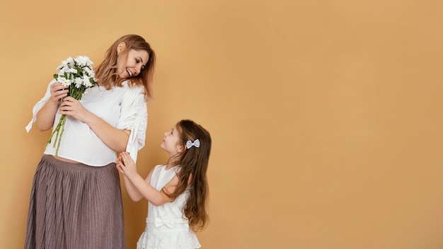 Madre e figlia con bouquet di fiori primaverili e copia spazio