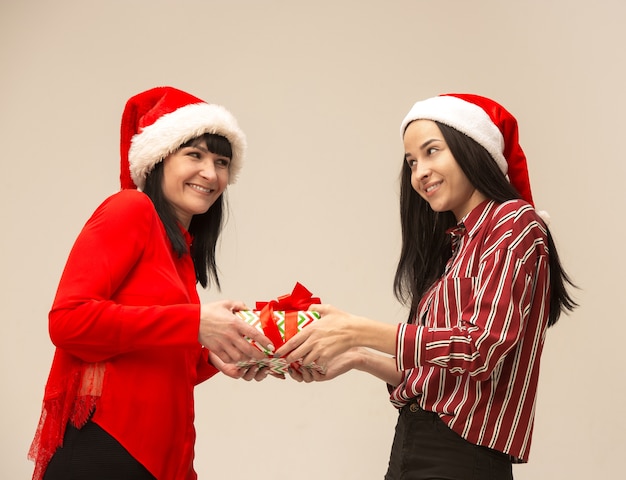 Madre e figlia con cappello da Babbo Natale e confezione regalo