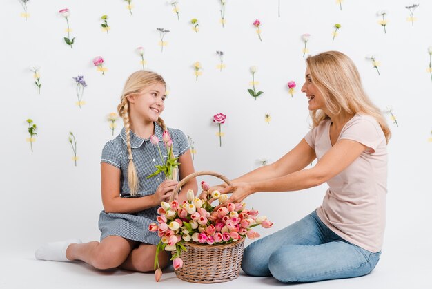 Madre e figlia con i fiori del cestino