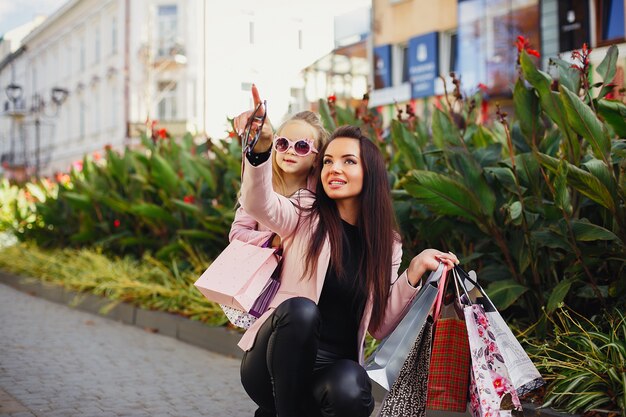 Madre e figlia con shopping bag in una città