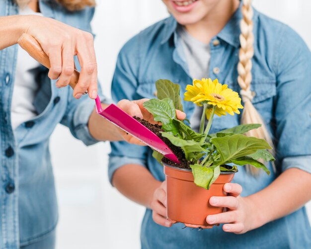 Madre e figlia del primo piano che piantano fiore