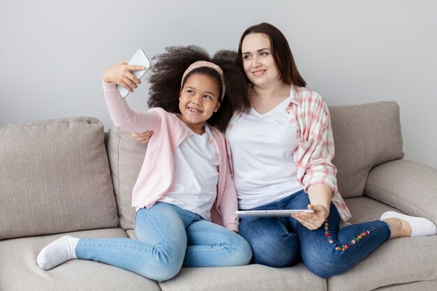 Madre e figlia felici che prendono insieme un selfie