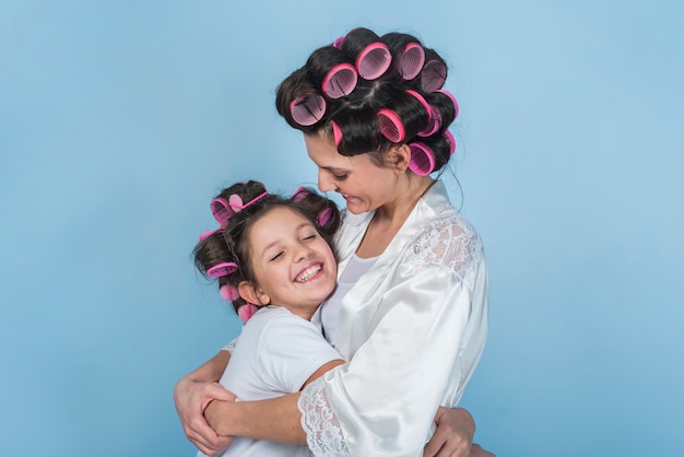 Madre e figlia in bigodini abbracci