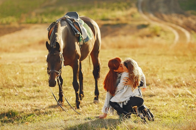 Madre e figlia in un campo che gioca con un cavallo