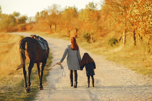 Madre e figlia in un campo che gioca con un cavallo