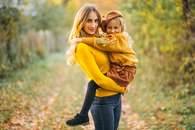 Madre e figlia nel parco pieno di foglie