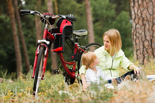 Madre e figlia rilassante accanto alla bici