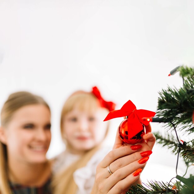 Madre e figlia sfocata decorare albero di natale