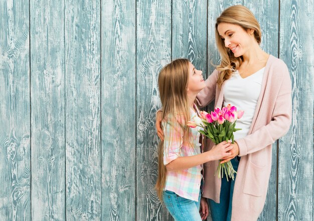 Madre e figlia soddisfatte che sorridono e che guardano l&#39;un l&#39;altro