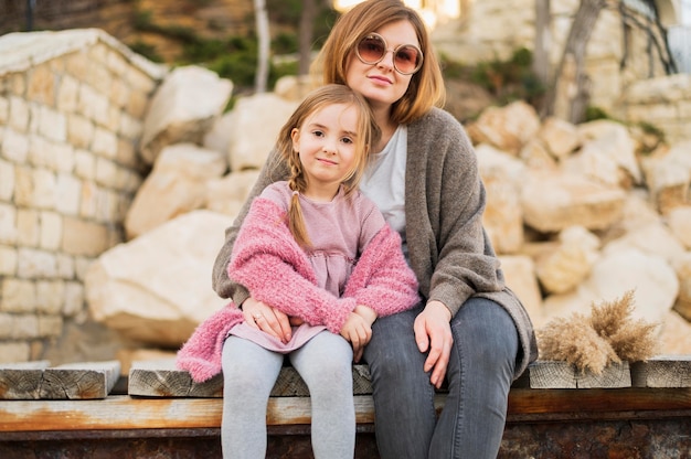 Madre e figlia svegli che posano all'aperto