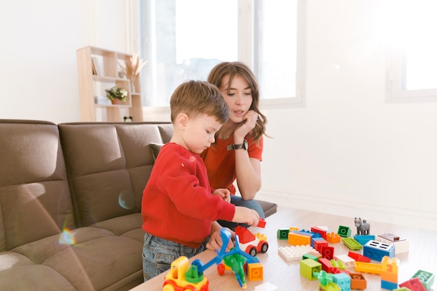 Madre e figlio a casa giocando con i giocattoli