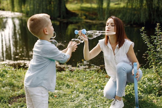 Madre e figlio che riposano nel parco e posano per una foto. Famiglia vestita di bianco e azzurro