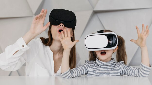 Madre e figlio che utilizzano cuffie da realtà virtuale e sono stupiti