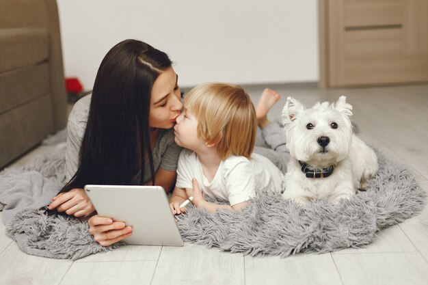 Madre e figlio piccolo si divertono a casa con il cane