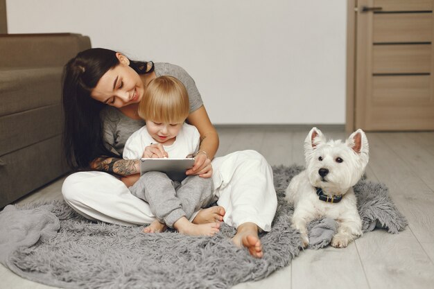 Madre e figlio piccolo si divertono a casa con il cane