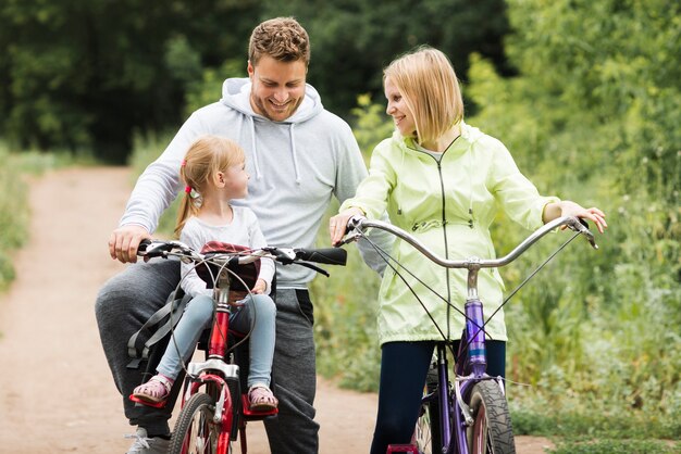 Madre e padre in bicicletta con la figlia