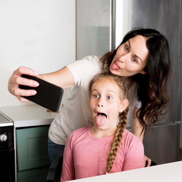 Madre e ragazza che prendono selfie