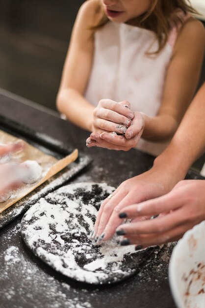 Madre e ragazza che producono i biscotti in cucina