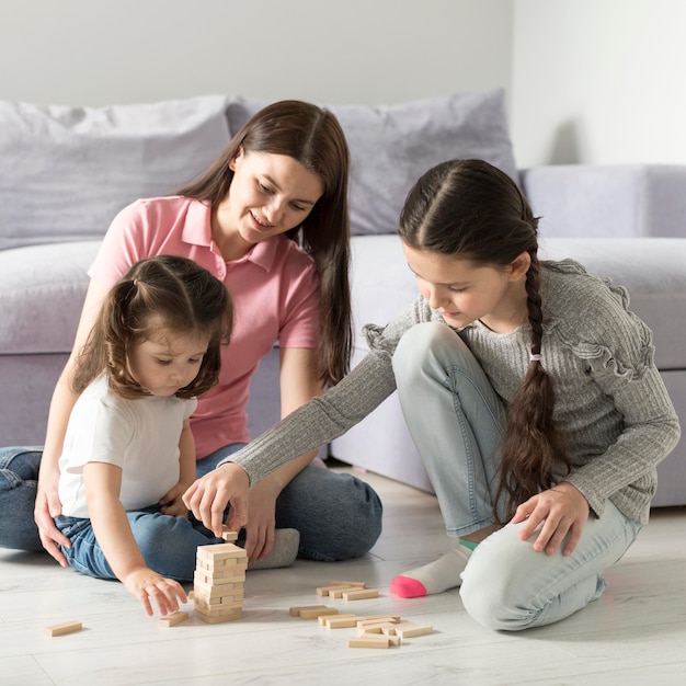 Madre e ragazze che giocano sul pavimento