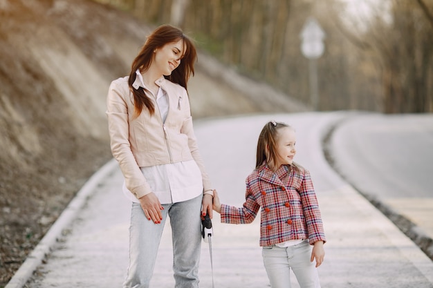 Madre elegante con la figlia in una foresta di estate