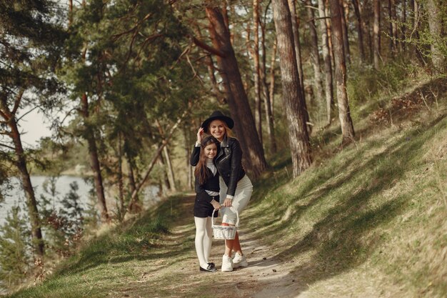 Madre elegante con la figlia in una foresta di estate