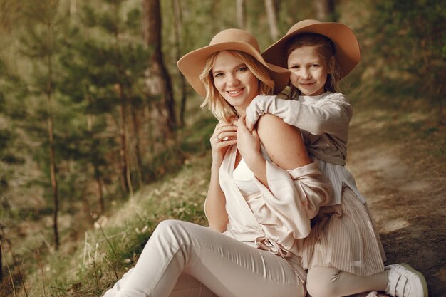 Madre elegante con la figlia in una foresta di estate