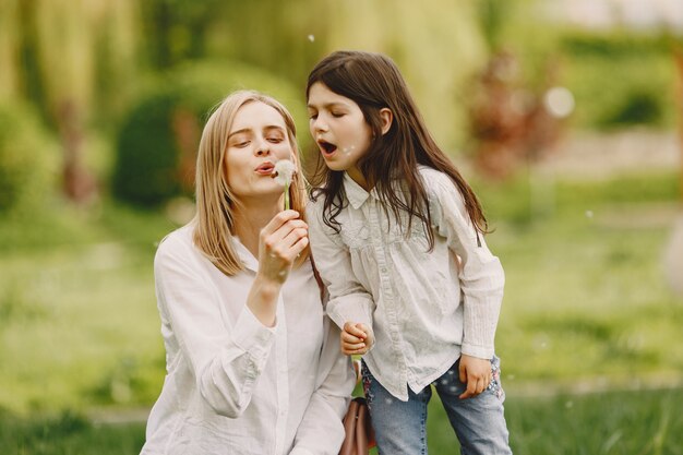 Madre elegante con la figlia in una foresta di estate