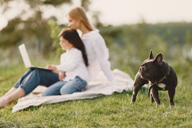 Madre elegante con la figlia in una foresta di estate