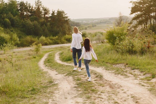 Madre elegante con la figlia in una foresta di estate