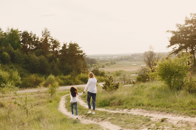 Madre elegante con la figlia in una foresta di estate