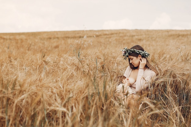 Madre elegante con la piccola figlia sveglia in un campo