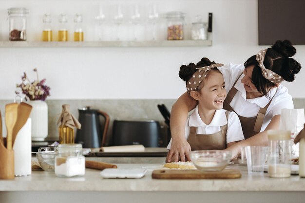 madre felice con la sua bambina che cucina a casa