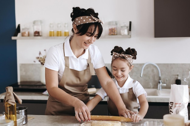 madre felice con la sua bambina che cucina a casa