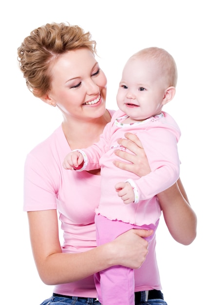 Madre felice di giovane bellezza con un sorriso attraente che tiene il suo bambino - isolato su bianco