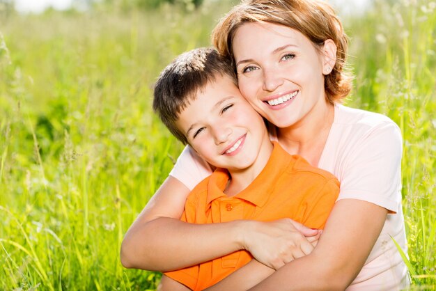 Madre felice e figlio nel ritratto all'aperto del prato di primavera