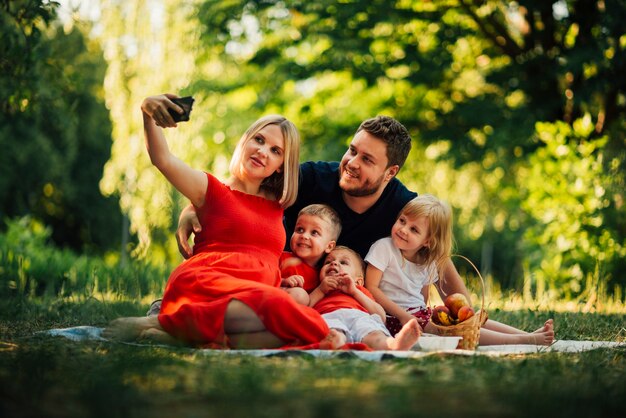 Madre prendendo un selfie di famiglia all&#39;aperto