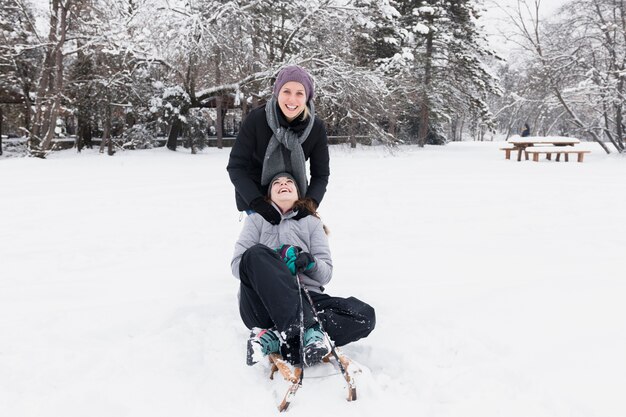 Madre sorridente con sua figlia divertendosi al giorno di inverno