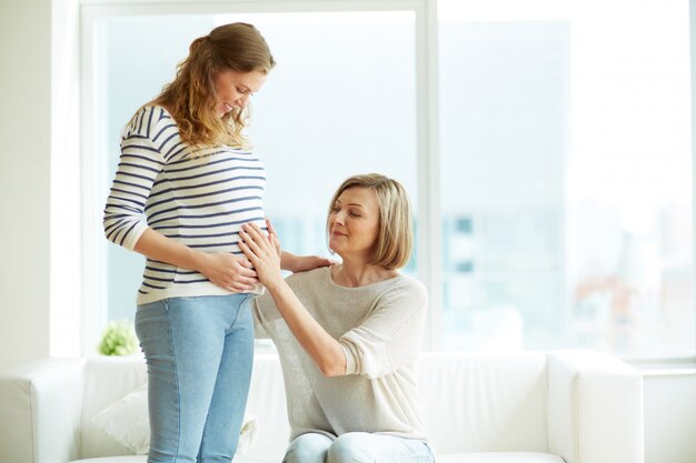 Madre tocca la pancia della sua figlia