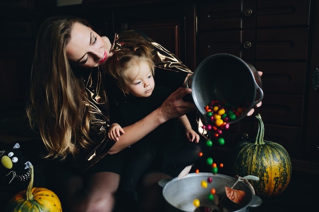 Madre versando caramelle in un&#39;altra ciotola mentre la figlia sembra