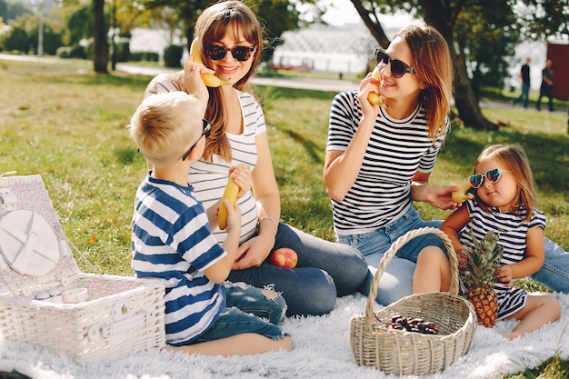 Madri con bambini che giocano in un parco estivo