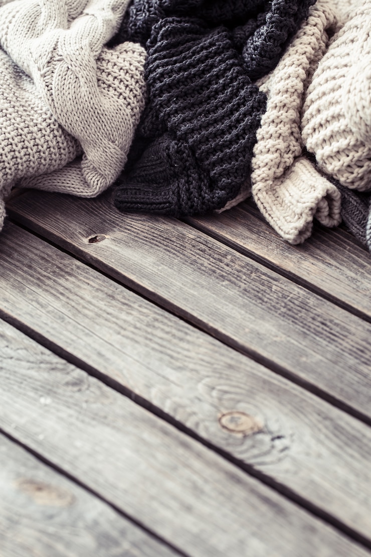 Foto gratuito maglione lavorato a maglia su una parete di legno