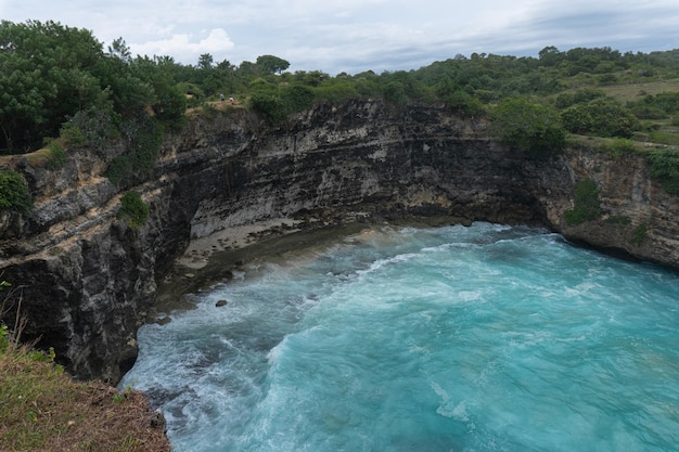 Magnifica vista sulle rocce naturali uniche e sulla formazione di scogliere nella bellissima spiaggia conosciuta come Angel's Billabong Beach situata sul lato est dell'isola di Nusa Penida, Bali, Indonesia. Vista aerea.