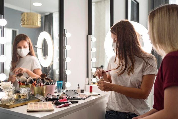 Make-up artist che indossa una maschera medica