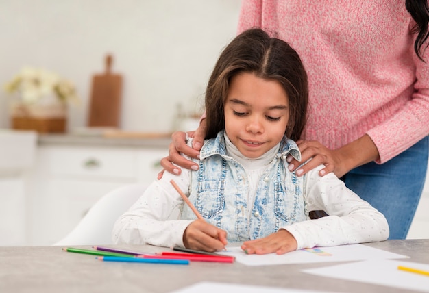 Mamma aiutando la figlia con una lezione