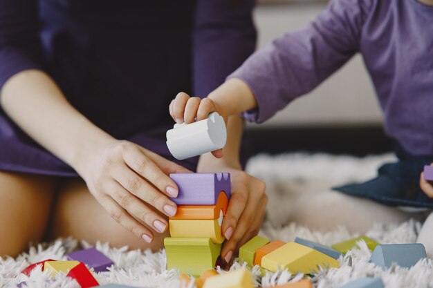 Mamma allegra che gioca ridendo con la figlia del bambino