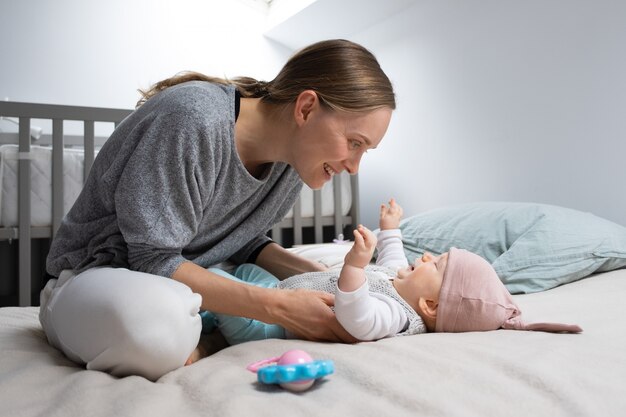 Mamma allegra positiva che gioca con la figlia del bambino