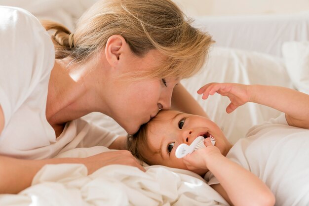 Mamma che bacia bambino sulla fronte