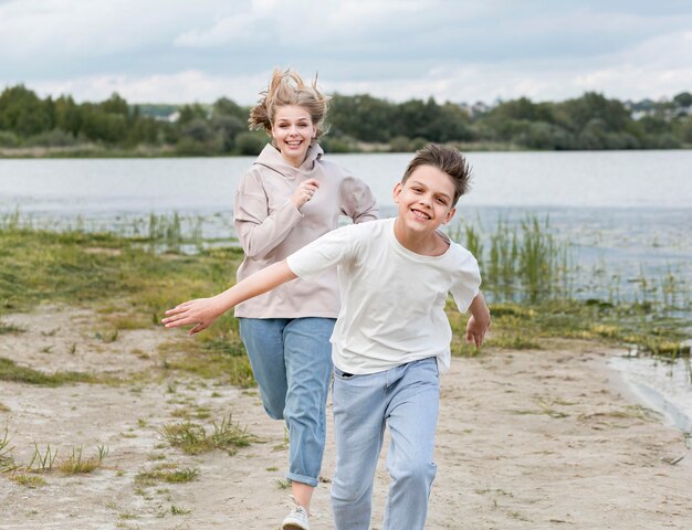 Mamma che corre con suo figlio sulla sabbia